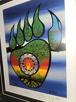 Close-up of the bear paw print artwork showing color details and artist signature.
