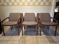 Front view of chairs arranged in a row on tiled floor with checkered wall background