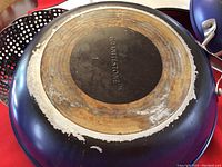 Bottom view of blue frying pan showing branded Granitestone II base with visible wear and use marks