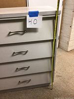 Front view of the dresser showing 4 drawers with metal handles and a measuring tape indicating a height of 40 inches.