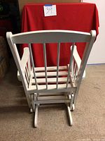 Back view of the white wooden gliding rocker chair, showing the vertical slat back and gliding base.