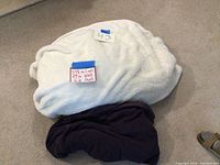 Bean bag chair showing white fluffy cover with handwritten size label and lot number on blue tape.