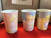 Three stackable Precious Moments collectible cups displayed side by side, each about 4.5 inches tall, showing their full illustrated designs.