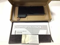Battery in original box packaging with instruction manual and additional paperwork visible.