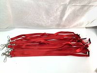 Overview of 10 red polyester lanyards with metal swivel hooks and black breakaway clasps spread out