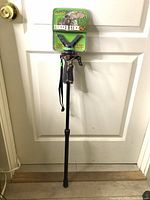 Primos Trigger Stick Short Mono Pod Gen 2 leaning against a door showing full length and packaging label on mounting head.