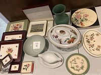 Photo showing overall lot contents including ceramic covered dish, plates, gravy boat, bowl, green vase, and table mats
