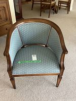 Front view of occasional chair showing wood frame and blue upholstery with white floral pattern, along with measurement tape indicating dimensions.