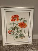 Framed watercolor artwork showing a bouquet of bright orange flowers with green leaves, signed by Valerie Pfeiffer. The frame is beige with a white mat and green double lines.