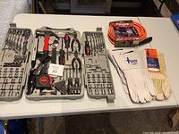 Full tool set open in case with tools organized and gloves and extension cord placed next to it
