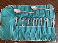 All eleven teaspoons laid in green Birks silvercloth roll