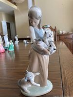 Full view of the Lladro porcelain figurine depicting a girl holding kittens.