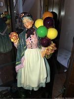 Front view of the Royal Doulton Balloon Lady figurine showing facial detail, clothing, flowers and balloons.