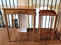 Photo showing both tables side by side: one with a small drawer under the tabletop and the other smaller table with a storage shelf below and raised edges.