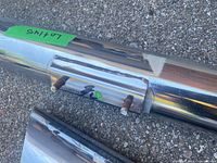 Close-up of threaded mounting studs welded to polished chrome pipe surface