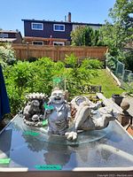 Glass Lazy Susan displayed outdoors on a table with various ceramic and decorative figurines around it.