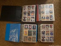 Four open binders filled with 1991 MLB trading cards arranged in plastic sleeves, showing a mix of player cards and special inserts.