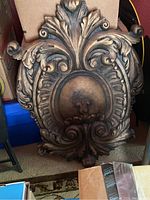 Full view of large decorative crest showing overall shape and detailing with heavy solid look.