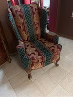 Full view of the wing back chair showing fabric patterns and wooden legs