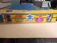 Side view of original yellow cardboard box showing '1990 Score Collector Set' label, quantity of cards included, and sample player image.