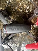 Top view of black aerial drone with 'Drone II X' marking showing slightly used condition.