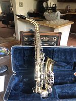 Saxophone with mouthpiece attached laid inside open case