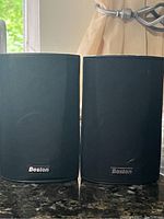 Photo of the pair of Boston bookshelf speakers with black metal grills, showing front view and logo.