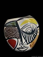 Front view of the vase showing the colorful Cubism-inspired abstract face painted on a white background.