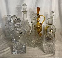 Front view of nine glass liquor decanters arranged in three rows
