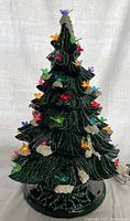 Front view of vintage ceramic Christmas tree with colorful bird lights illuminated.