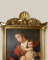 Close-up of the vintage original oil painting showing the woman and child in rich colors with a gilded ornate frame surrounding the canvas.