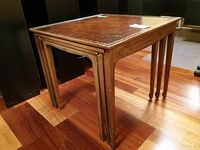 Side view of three wooden nesting tables stacked together, showing profile and leg details.