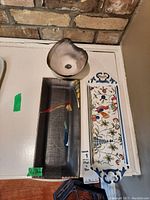 Lot items from top view showing three ceramic pieces: small bowl, colorful decorative plate, dark rectangular plate.