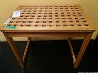 Front elevated view showing the lattice top of the wooden table with noticeable scratches and wear along the edges.