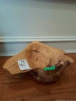 Photo showing the wood decorative bowl's irregular shape, cracks, and natural wood grain patterns, with the lot label on the bowl.