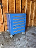 Front and side view of the blue Husky rolling tool chest showing six drawers and wheels.