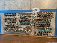 Top-down photo showing  multiple bracelets and necklaces arranged in rows including bead designs, metallic chunky chains, and stone accents.