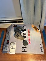 Sony PlayStation console box with official grey Dual Shock wired controller on top