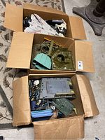 Three cardboard boxes containing a white jet, green vehicle parts, B.A.R.T. units and assorted figures