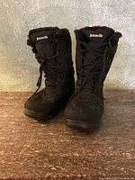 Front view of the pair of black Kamik snow boots showing the warm lining and laces.