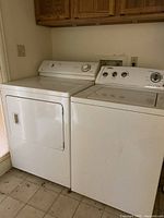 Shows white top-load Maytag washer with control panel, full agitator; adjacent dryer visible but not included