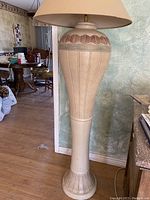 Full view of tall ceramic floor lamp with Southwest pattern and beige lampshade