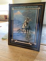 Framed art print showing a Native American on horseback surrounded by wolves in a snowy environment, artist name and title visible.