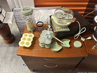 Full set of Baby Bullet appliances and storage items on a wooden surface.