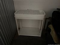 White baby changing table with changing pad and storage shelf