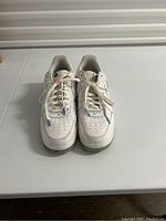 Front view of white Nike Air Force 1 low cut men's sneakers size 13 showing lace design and perforated toe box.
