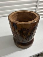 Top angled view showing the rounded top rim and detailed floral carving on wooden planter.