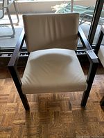 Front-facing view of the faux leather armchair showing the seat and backrest surrounding the hardwood frame.