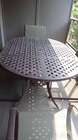 Top and overall view of the metal patio table on an enclosed porch.
