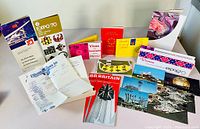 Photo showing collection of colorful paper souvenirs including brochures, postcards, pamphlets and tickets from Expo 67 and Expo 70.
